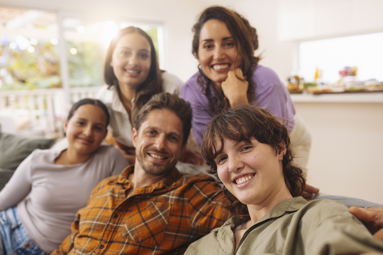 On the couch, the family huddles for a perfect living room selfie