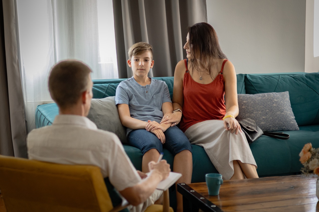 Therapy session. Professional psychologist, psychiatrist listening woman and her son patients and looking for solutions in family relationship.